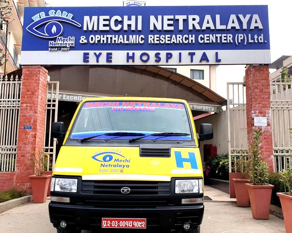 Yellow ambulance in front of Mechi Netralaya eye hospital entrance