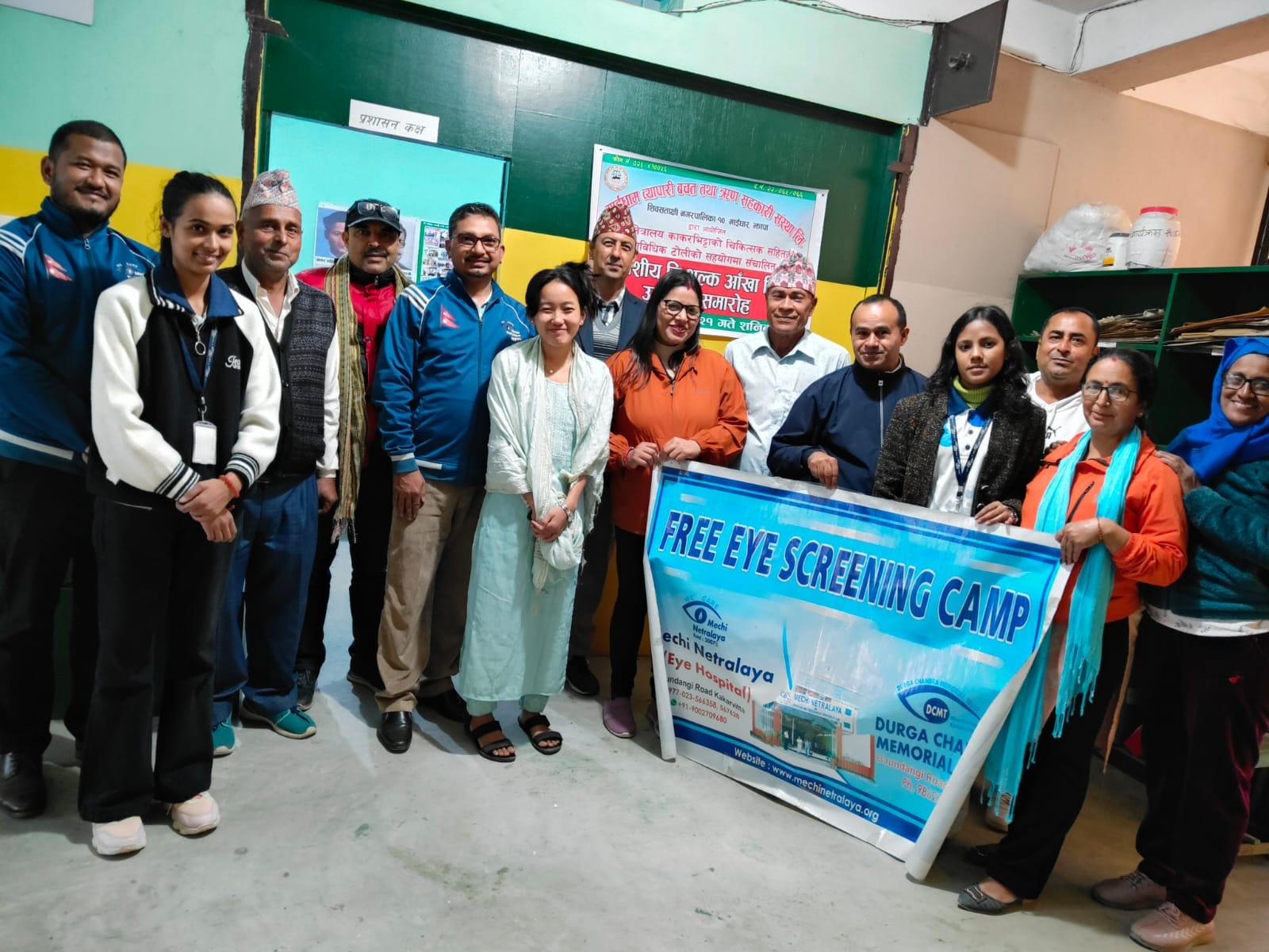 Group of people holding a free eye screening camp banner