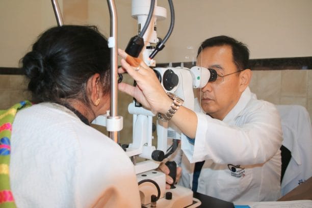 Eye doctor examining a patient's eyes with an ophthalmoscope