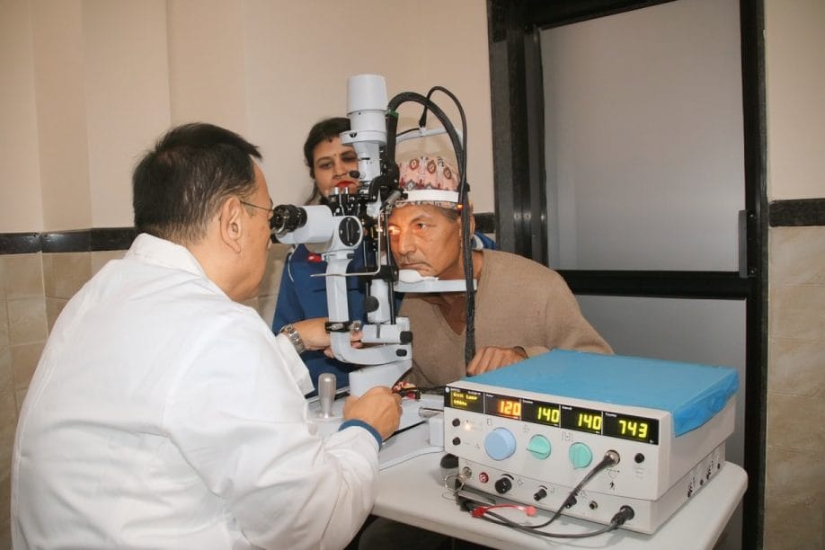 Doctor examining patient's eyes with medical equipment