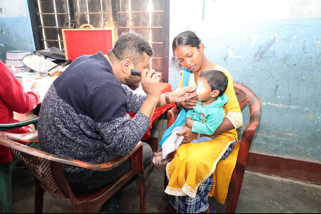 doctor examining a baby's eyes with an ophthalmoscope